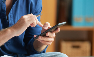 Administrador de fincas usando un teléfono móvil para trabajar en tucomunidapp.com