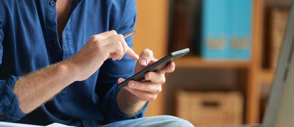 Administrador de fincas usando un teléfono móvil para trabajar en tucomunidapp.com
