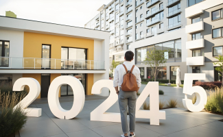 Un joven mira al frente, de espaldas a la cámara ante una moderna edificación. En el suelo unos grandes números indican el paso del año 2024 al 2025.