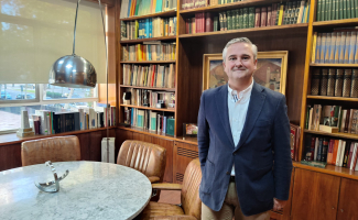 Juan López-Asiaín, Director del Gabinete Técnico de Consejo General de Arquitectura Técnica de España, posa ante una mesa de su despacho