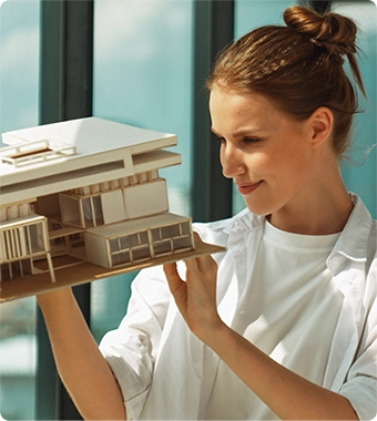 Una mujer mirando la maqueta de una vivienda