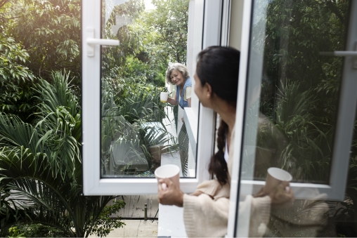 Vecinas charlando por la ventana con un cafe